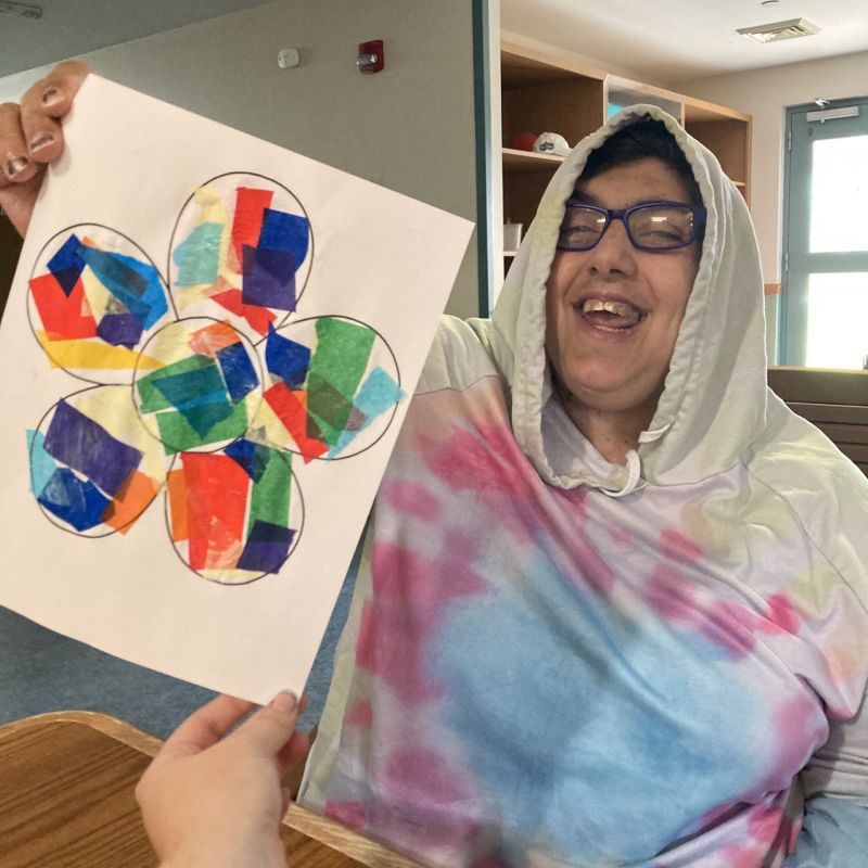 Individual smiling with flower art